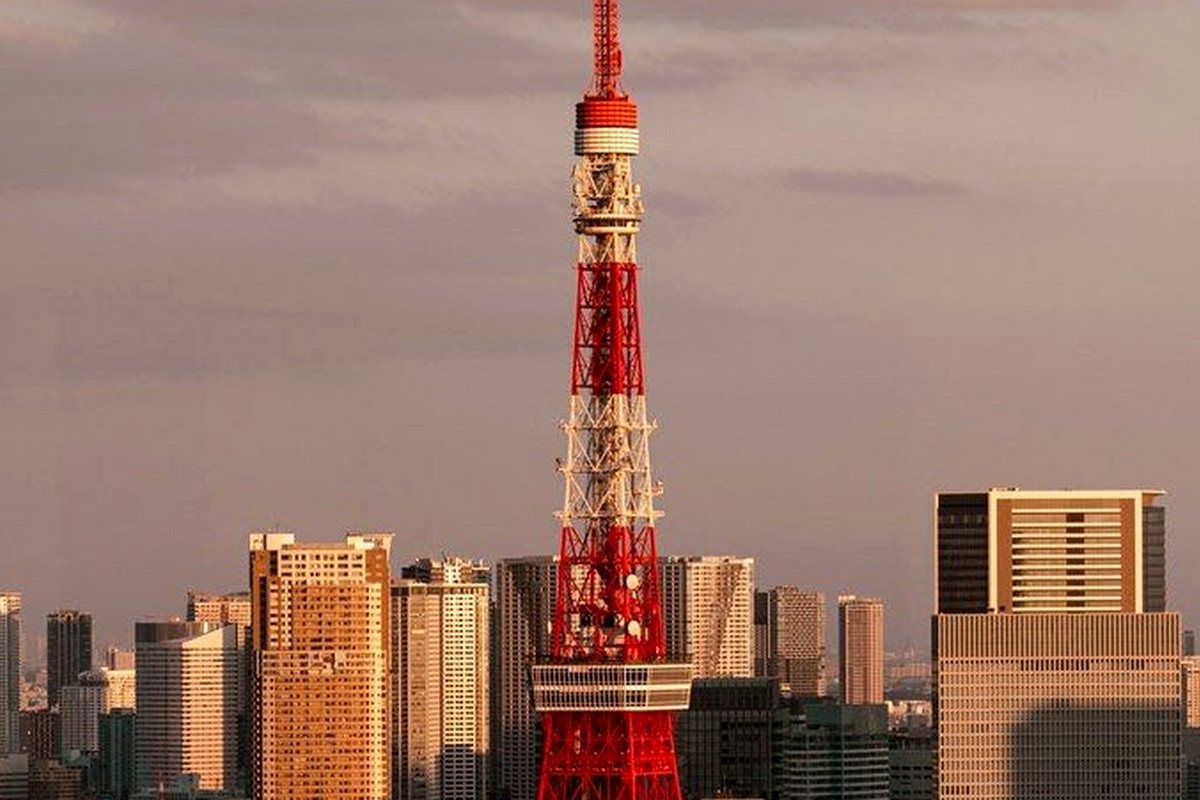 A tall red-and-white city landmark rising above surrounding buildings.
